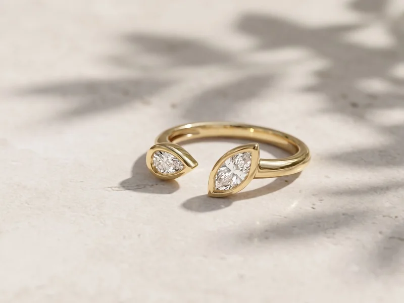 Levendi Jewellers homepage hero image: Classic open pear and marquise diamond engagement ring on pale stone